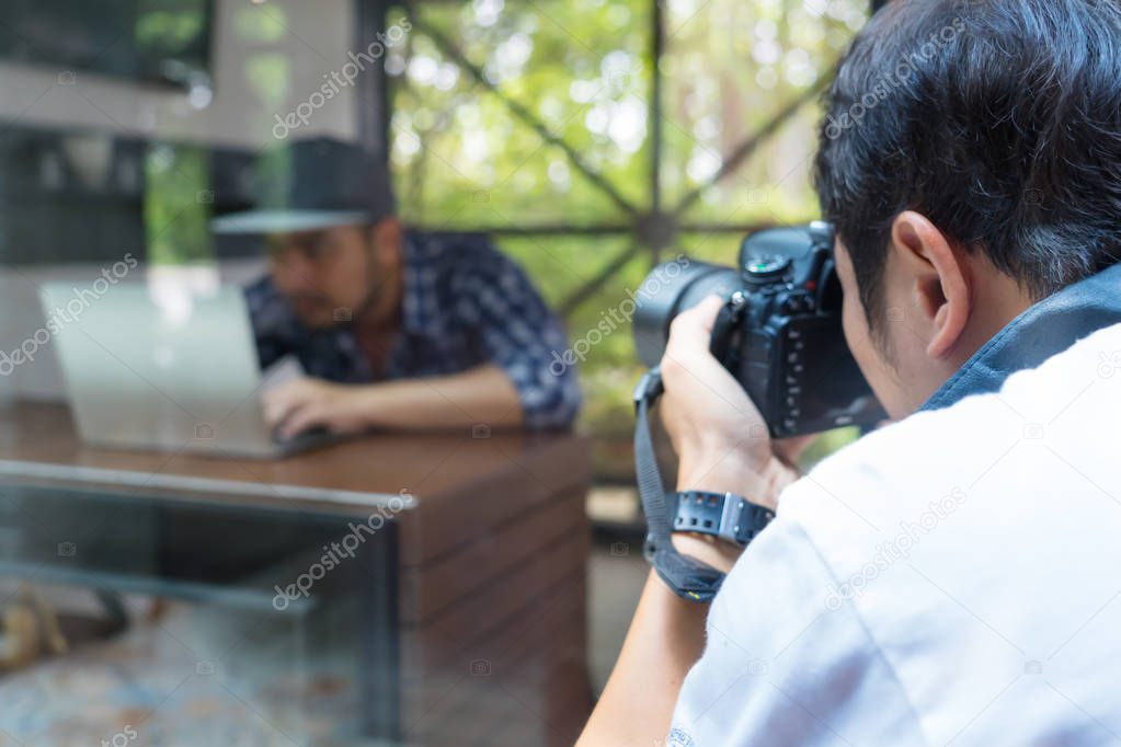 Asian photographer man using digital camera shooting concept young business man model in the studio for stock photo business