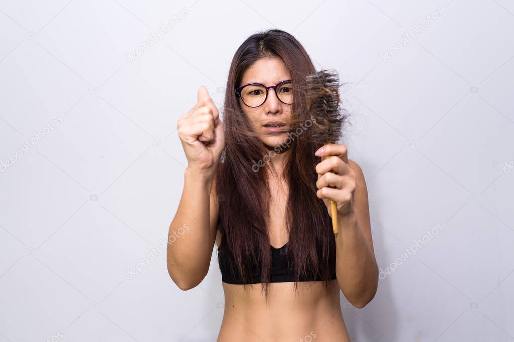 Woman with hair loss holding comb. Young girl losing  hair problem, falling hair on brush healthy medical treatment concept.