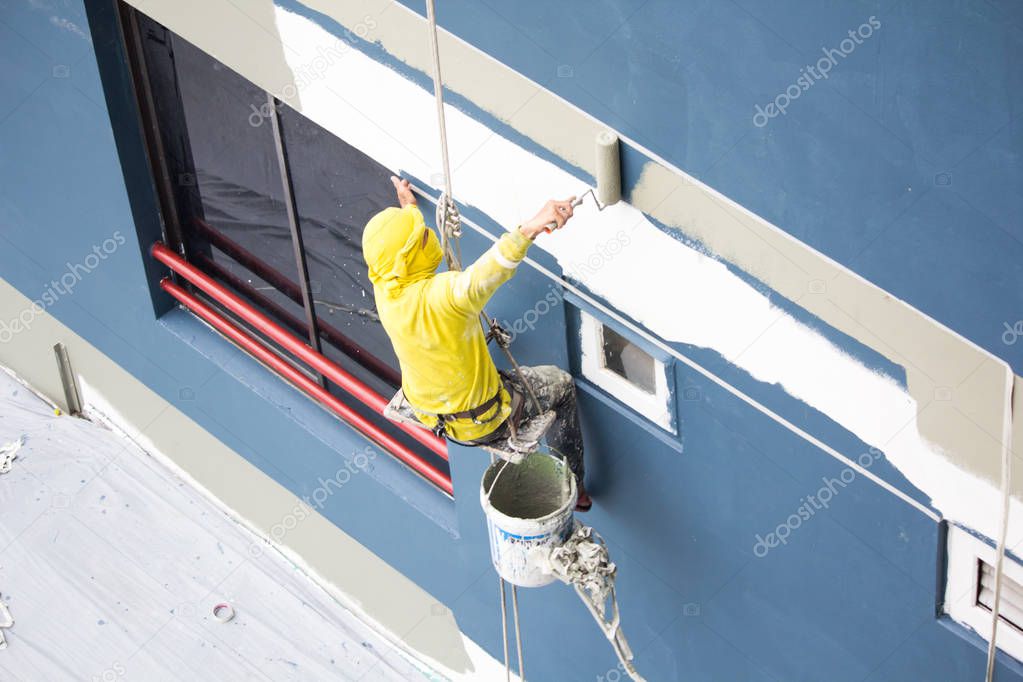 painters hanging on roll, painting color on building wall