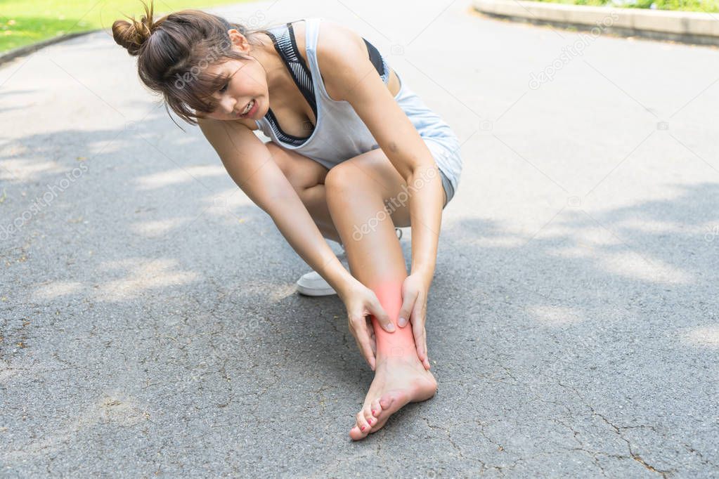 Woman painful legs, ankle muscle pain. Young Asian girl hurt from an ankle injury. Runner female massaging suffering foot from exercising and running. Sport workout exercise injured concept.