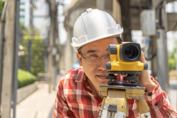 Civil engineer land survey with tacheometer or theodolite equipment. Worker Checking construction site on the road. Surveyor engineer making measuring with theodolite instrument level tool.