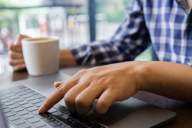 Bilgisayar laptop klavye yazarak ve kahve fincanı holding iş adam elini kapat
