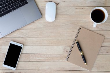 İş ofis büro dizüstü, smartphone, fincan kahve ve malzemeleri ile. ahşap arka plan üzerinde. Üstten görünüm kopya alanı, düz ile yatıyordu.