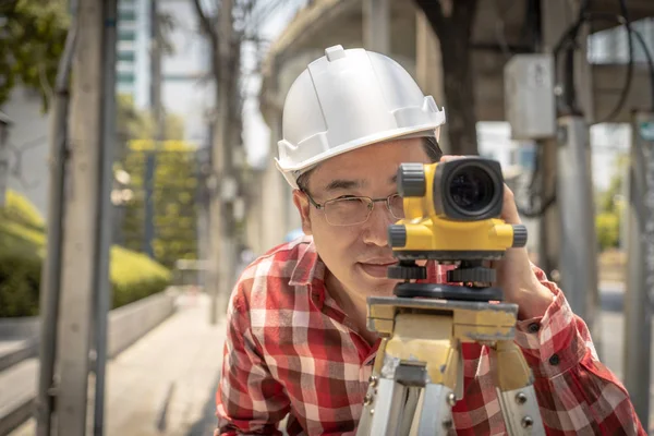 Civil engineer land survey with tacheometer or theodolite equipment. Worker Checking construction site on the road. Surveyor engineer making measuring with theodolite instrument level tool.