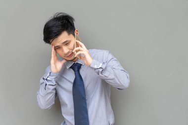 Cep telefonu ile kopya alanı gri arka plan üzerinde konuşurken ciddi iş adamı.