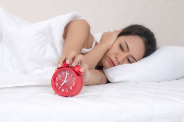 Genç kadın esneme uyanış çalar saat tutarak yorgun. sabah erken uyanmak. Kız Dur erteleme alarm. Erkek uyanmak uykulu ve yorgun. kadın uyan sabah çalar saat erteleme kavramı ile.