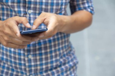 Mobil akıllı telefon kullanarak iş adamı ele. Orta bölüm adam iyi giyimli holding telefonu kısa mesaj yazarak kapatın. Telefonu bağımlılığı konsepti