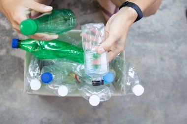 El açık tutarak ve yeşil geri dönüşümlü plastik şişe geri dönüşüm için kağıt çöp kutusu koyarak. toprotection dünya çevre kavramı atık yönetimi ve plastik yeniden sırala.