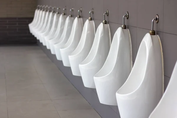 Männer öffentliche Toilette, Toilette für Männer. Herren Latrine WC Badezimmer. Reihe Urinale weiße Keramik in modernen Toiletten mit Kopierraum. — Stockfoto