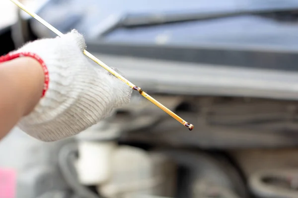 Meccanico automatico che controlla il livello dell'olio motore dell'auto. Primo piano meccanico riparazione a mano auto con cappuccio aperto, controllo meccanico livello lubrificante motore, servizio di manutenzione auto fissaggio in officina garage . — Foto Stock