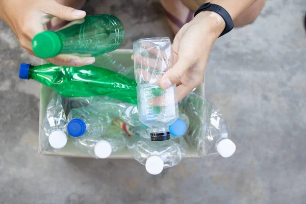 El açık tutarak ve yeşil geri dönüşümlü plastik şişe geri dönüşüm için kağıt çöp kutusu koyarak. toprotection dünya çevre kavramı atık yönetimi ve plastik yeniden sırala.