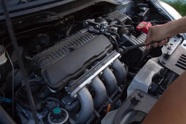 Meccanico, tecnico con chiave inglese che controlla il motore dell'auto. servizio auto, riparazione, fissaggio, controllo di lavoro di manutenzione presso officina garage di riparazione auto. concetto di veicolo di ispezione . — Foto Stock