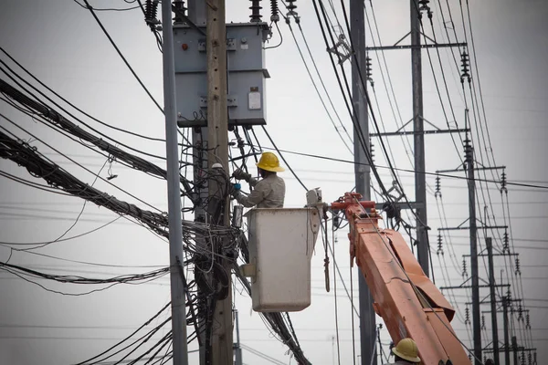 Elektrikçiler Kablo montaj ve onarım hizmetleri, Teknisyen kutup üzerinde kırık elektrik teli sabitleme kontrol.