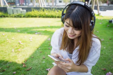 Beyaz elbiseli mutlu genç kadın pa oturan müzik dinleme