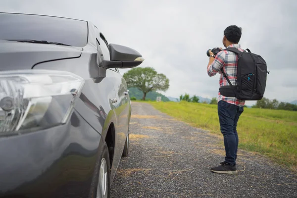 Close up front car on road trip with Young man taking photo on vacation. — Stock Photo, Image