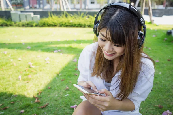 Beyaz elbiseli mutlu genç kadın pa oturan müzik dinleme