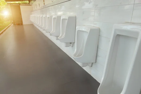Urinoirs dans les toilettes de messieurs publics. Toilettes publiques pour hommes, toilettes pour hommes. Gents toilettes wc salle de bain. rangée urinoirs céramique blanche dans les toilettes avec espace de copie. concept intérieur et soins de santé . — Photo