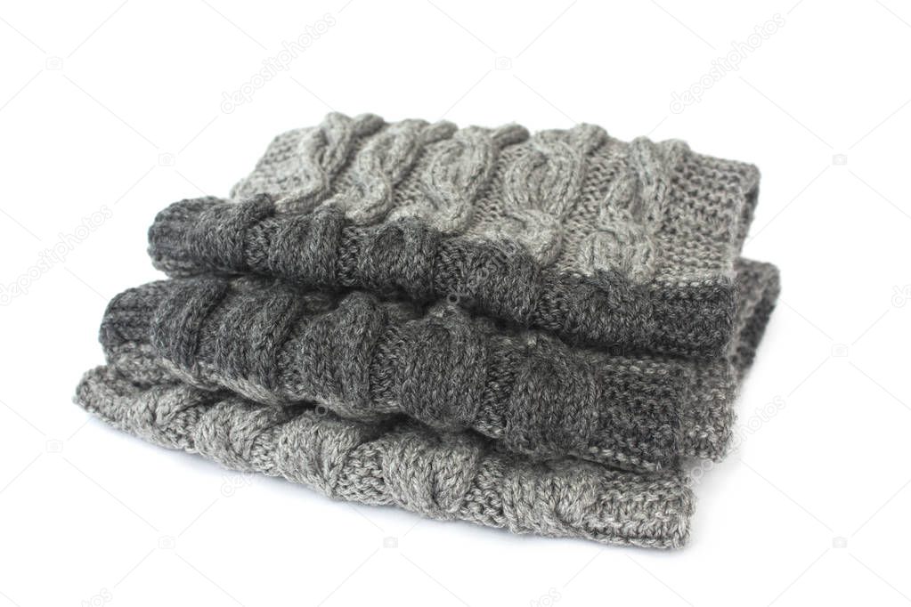 Knitted hands a scarf of dark green colour on a white background.