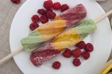 Ahududu ve nane ile süslenmiş bir tabakta meyve dondurma.