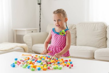 Renkli oyuncaklar ile oynama renkli elbise sevimli küçük kız.