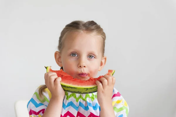 スイカの大きなスライスを食べて明るいドレス愛らしい少女 — ストック写真