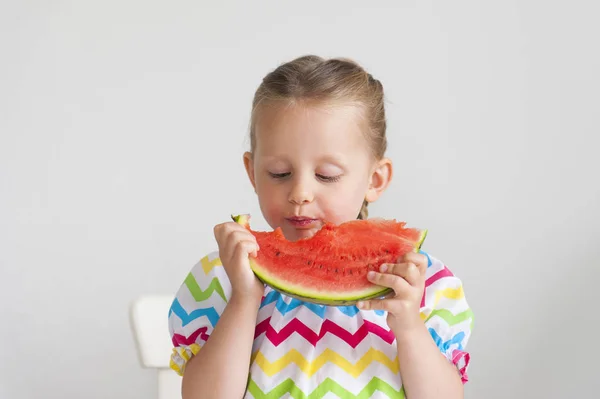 スイカの大きなスライスを食べて明るいドレス愛らしい少女 — ストック写真