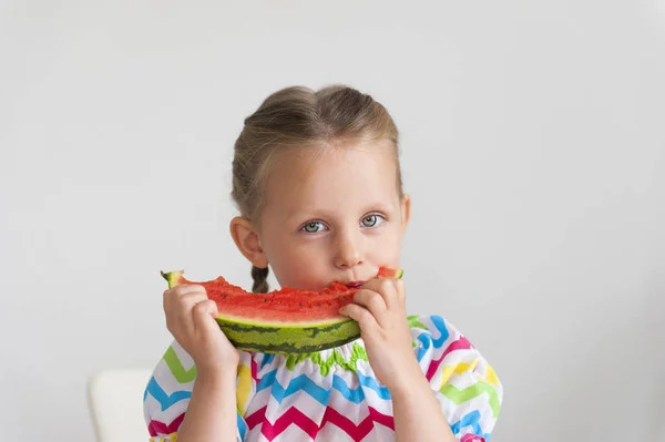 スイカの大きなスライスを食べて明るいドレス愛らしい少女 — ストック写真