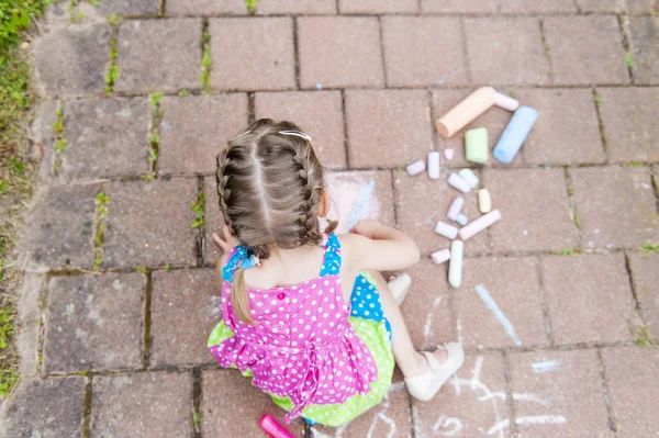 コンクリート アスファルト正方形にカラフルなドレスの女の子が座っています 子図面絵画アスファルト コンクリート — ストック写真