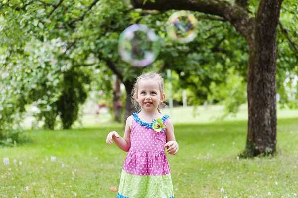 Liten Söt Tjej Ljus Klänning Tittar Såpbubblor Sommar Park Stockbild