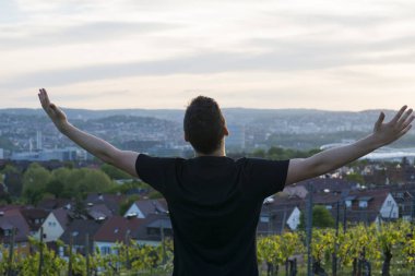 Genç adam uzanmış silah ve uzak seyir ile bir bağ duran bir siyah gömlekli