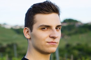 Çok güzel delikanlı modeli bir sırıtma ile kameraya akşam görünüyor.