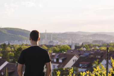 Genç adam ile tekrar şehir ve ufuk çizgisi akşamları bakarak fotoğraf duruyor