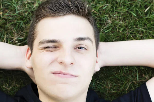 Portret Van Een Geweldige Jongeman Het Gras Ligt Met Zijn — Stockfoto