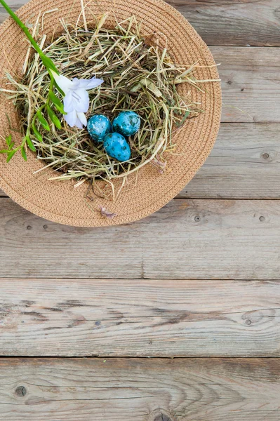 枝編み細工品帽子と花と塗装の斑点を付けられたイースター卵の巣 左上隅にあります テキスト スペース — ストック写真