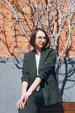 Sokaklarda poz bir takım elbise genç güzel kadın. Tonlama.