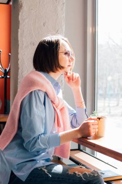 Genç güzel kadın bir kafede kahve içme. Tonlama.