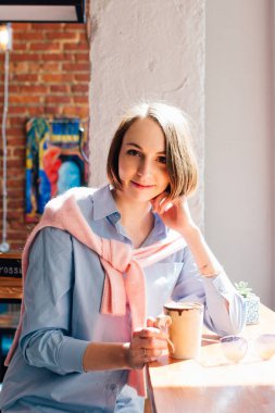 Genç güzel kadın bir kafede kahve içme. Tonlama.