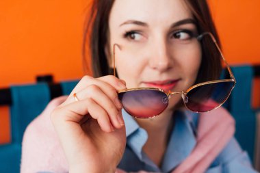 Kahve içme ve gözlük bir kafede tutan genç güzel kadın. Yakın çekim gözlük. Tonlama. Seçici odak.