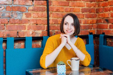 Genç güzel kadın bir kafede kahve içme. Tonlama.