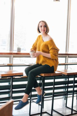 Genç güzel kadın bir kafede kahve içme. Tonlama.