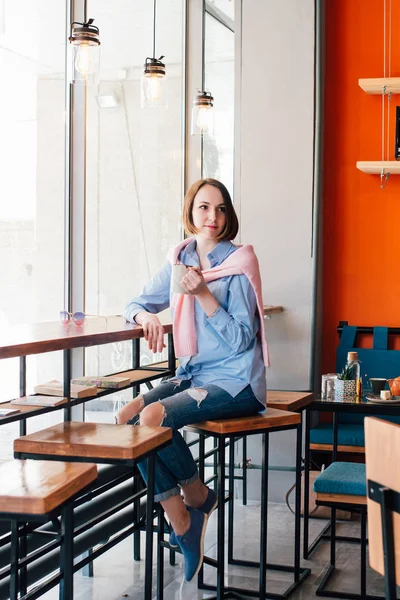 Genç güzel kadın bir kafede kahve içme. Tonlama.