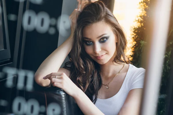 Zarif beyaz elbiseli uzun saçlı Genç güzel esmer kız. Gün batımında akşamları şehrin sokaklarında yürüyen kadın.