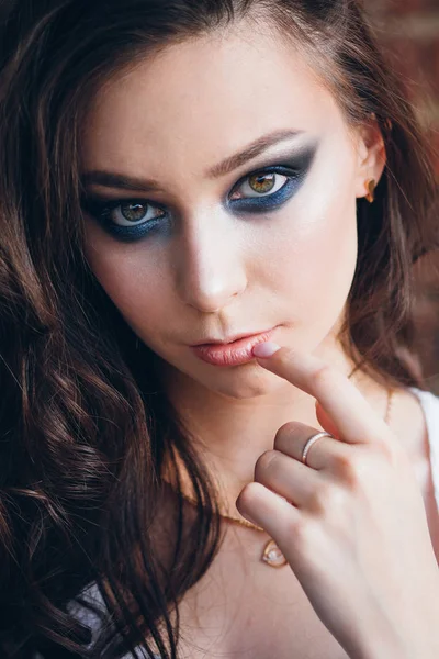 Zarif beyaz elbiseli uzun saçlı Genç güzel esmer kız. Gün batımında akşamları şehrin sokaklarında yürüyen kadın.