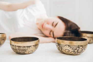 Genç güzel kız masaj terapisi şarkı yapıyor kaplıcada kase. Gevşeme ve alternatif tıp kavramı. Tonlama.