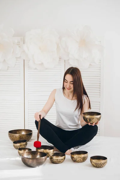 Massage therapist plays on singing bowls for a vibrational massage in the Spa. The concept of relaxation and alternative medicine. Toning.