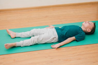 Sevimli küçük çocuk spor salonunda yoga yapmak öğrenme. Spor ve sağlıklı yaşam kavramı.