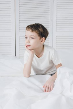 Sevimli çocuk sabah ve uykulu oturan yatakta uyandım 