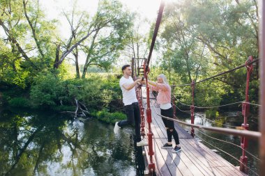 Çift adam ve kız nehir üzerinde köprüde etrafında aptal