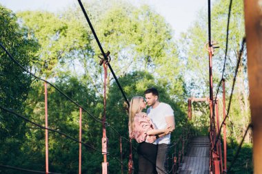 Genç çift adam ve kız nehir üzerinde köprü ve öpücük 