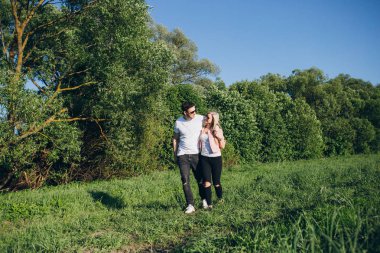 Genç çift adam ve kız yolda kol kola yürüme 